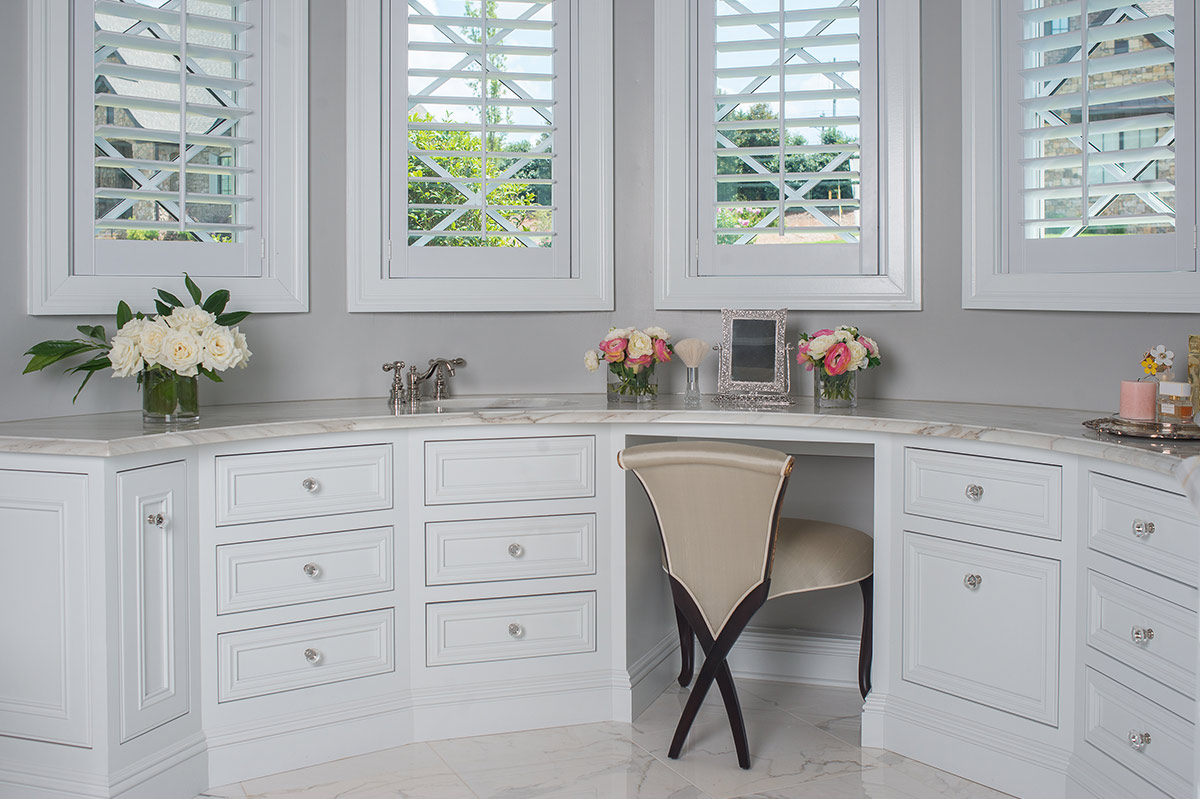 Custom bathroom vanity with drawer storage and a paneled desk